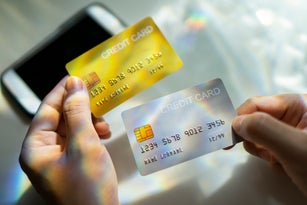 Close up Hand holding Blank credit card  black,gold,platinum color with spectrum light and shadow background