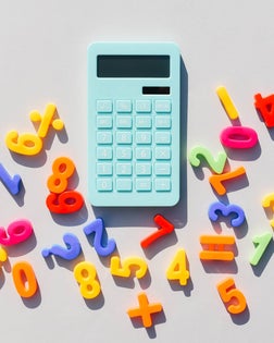 Blue calculator and math symbols on a universal gray background. Gray background. Blue calculator. Math symbols.