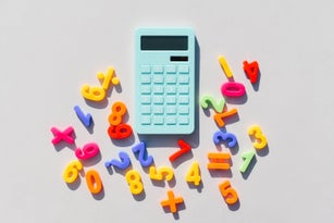 Blue calculator and math symbols on a universal gray background. Gray background. Blue calculator. Math symbols.