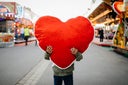 Young Boy Holding Large Soft Heart Toy At Fun Fair