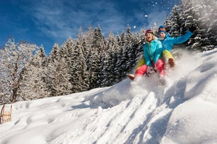 Austria, Salzburg, Young man and woman with sledge in snow at Altenmarkt Zauchensee