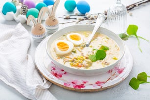 Homemade polish Easter soup with addition of sausage, hard boiled egg and vegetables in a bowl