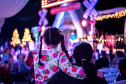 Mother and child are waiting for Santa at a Christmas tree lighting ceremony.