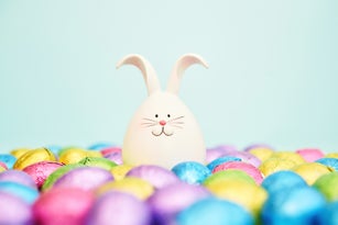 Cute Easter bunny in a sea of chocolate Easter eggs