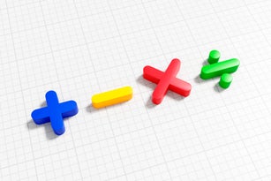 Math symbols of addition, subtraction, multiplication and division on graph paper