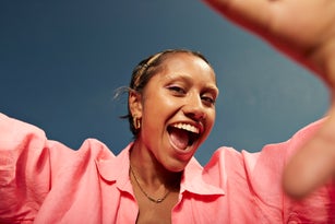 Young woman screaming against sky