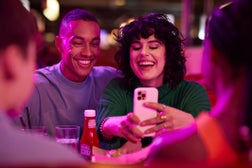 Cheerful woman taking selfie with man