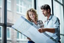Two architects checking blueprint