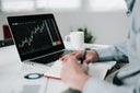 Young businessman using laptop for analyzing data stock market.