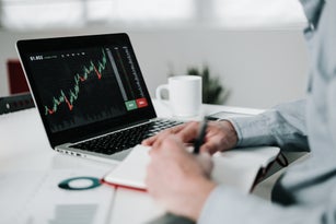 Young businessman using laptop for analyzing data stock market.