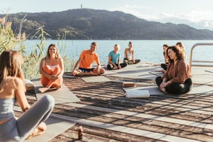 Men and women talking to female instructor during yoga class
